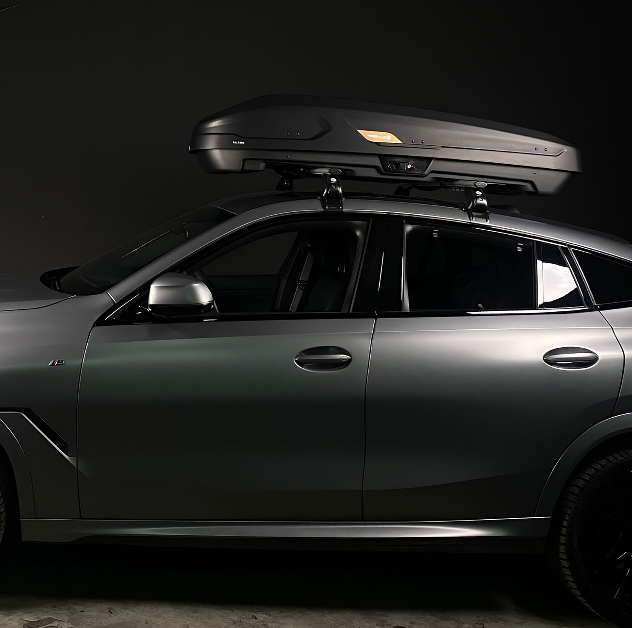 Coche gris con techo liso, barras de techo y cofre portaequipajes negro montado